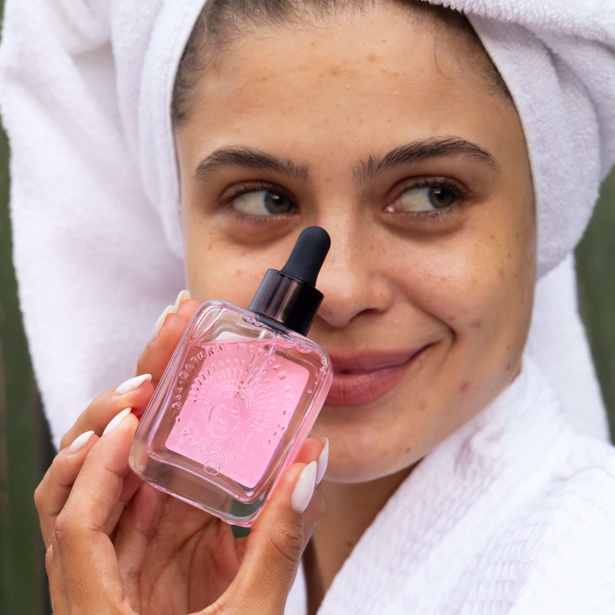 Women with acne holding a natural skincare bottle of regenerating serum in her hands