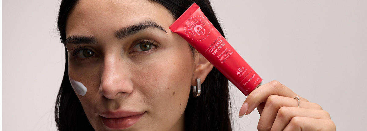Viva Maia Tamarind & Zinc Oxide Shielding Sunscreen SPF 45+ held to a woman's forehead, cream swipe on her cheek.